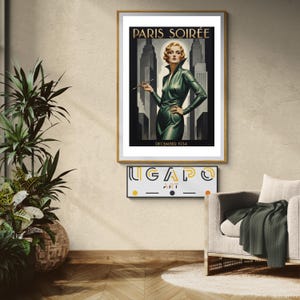 May include: A framed art print titled "Paris Soirée" featuring a woman in a green dress holding a cigarette holder, set against a backdrop of Art Deco skyscrapers. The print is in a gold frame. Below is a sign that says "UGAP ART".