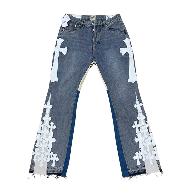 May include: Blue denim jeans with white cross appliqu&eacute;s on the front and back. The jeans have a flared leg design with a raw hem. The jeans have a light wash and a classic five-pocket design.