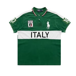 Pu&ograve; includere: Polo verde con dettagli bianchi e la scritta "ITALY" sul petto. Presenta un logo di giocatore di polo bianco e il numero "10" sulla manica. Il colletto ha finiture rosse e bianche.