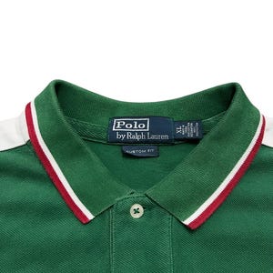 Pu&ograve; includere: Polo verde con finiture bianche e rosse sul colletto. La camicia ha una chiusura a tre bottoni e il logo "Polo by Ralph Lauren" sull'etichetta. Vestibilit&agrave; personalizzata, taglia XL.