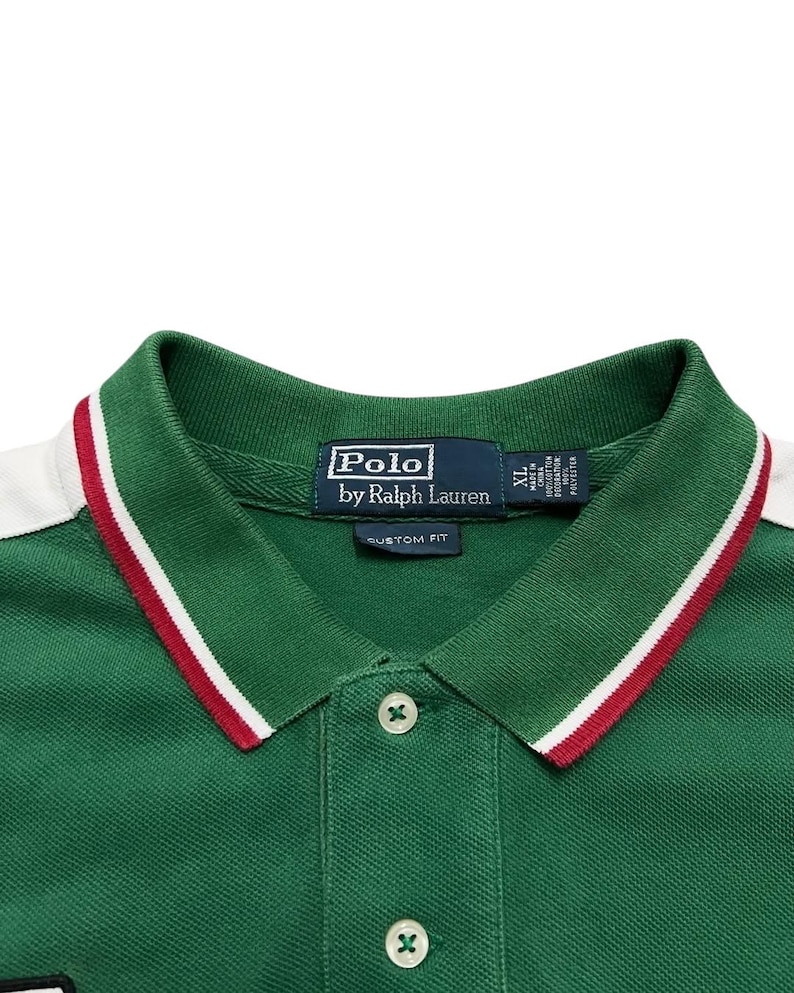 Pu&ograve; includere: Polo verde con finiture bianche e rosse sul colletto. La camicia ha una chiusura a tre bottoni e il logo "Polo by Ralph Lauren" sull'etichetta. Vestibilit&agrave; personalizzata, taglia XL.