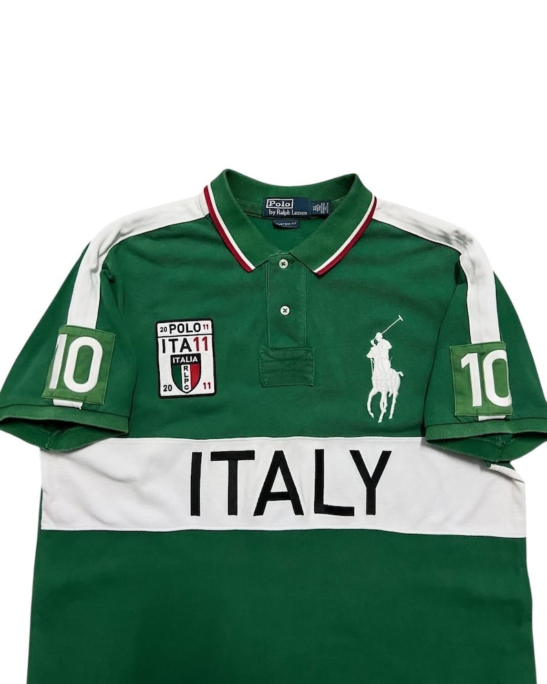 Pu&ograve; includere: Polo verde con dettagli bianchi e la scritta "ITALY" sul petto. Presenta il numero "10" sulle maniche e un logo bianco ricamato di un giocatore di polo. Include una piccola toppa con testo.