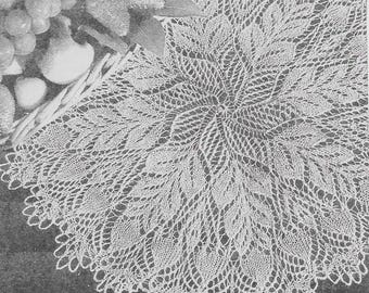 May include: A white, circular lace doily featuring a detailed leaf pattern. The doily has a scalloped edge, and the image is a close-up, highlighting the intricate design and texture of the handmade textile.