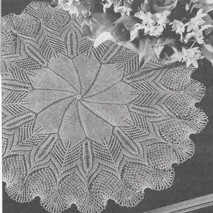 May include: An off-white, crocheted doily with an elaborate starburst pattern at its centre. The lace design includes a scalloped edge and openwork details. This handmade doily would add a vintage feel to any home. The measurements are in centimetres.