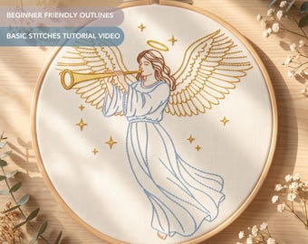 Può includere: Un telaio da ricamo contenente tessuto bianco con un disegno ricamato di un angelo che suona una tromba dorata. L'angelo ha grandi ali, un'aureola e una veste fluida delineata con filo blu. Piccole stelle dorate circondano la figura.