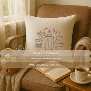May include: A cream-colored square pillow with a black line drawing of travel-related items, including a suitcase, passport, camera, and headphones. Text on the pillow reads "PDF INSTANT DOWNLOAD", "BEGINNER FRIENDLY OUTLINES", and "BASIC STITCHES TUTORIAL VIDEO".