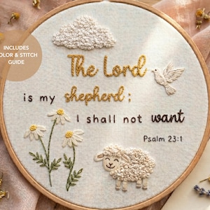 Puede incluir: Arte bordado en bastidor con el texto "The Lord is my shepherd: I shall not want" y "Psalm 23:1". El diseño incluye una nube, una paloma, margaritas y una oveja. Flores secas rodean el bastidor.
