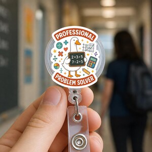 Peut inclure: Un enrouleur de badge circulaire illustré d'une oie blanche tenant un tableau noir avec le texte 2+3=5 et 7-2=5. Le design comprend le texte PROFESSIONAL PROBLEM SOLVER, une calculatrice, une règle et divers symboles mathématiques.