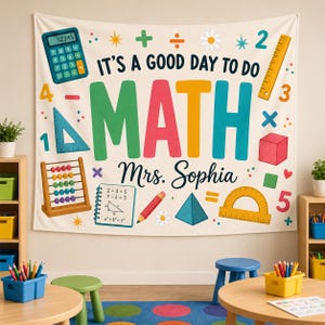 May include: A white fabric wall hanging featuring the text IT'S A GOOD DAY TO DO MATH and Mrs. Sophia. The design includes colorful illustrations of a calculator, ruler, abacus, protractor, pencil, and geometric shapes on a cream background.