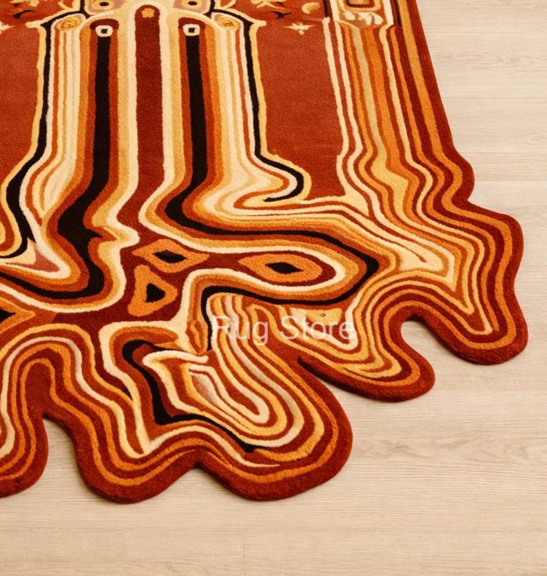 May include: A unique, abstract rug with a flowing, organic design. The rug features a palette of warm colors, including shades of brown, orange, and cream, with black accents. The edges have a wavy, irregular shape. The text "Rug Store" is visible.