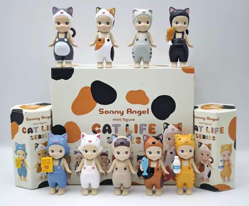 May include: A selection of Sonny Angel mini figures from the Cat Life series. The figures are dressed in cat-themed outfits, with various colours and accessories. The packaging features the series name and cat-themed graphics.