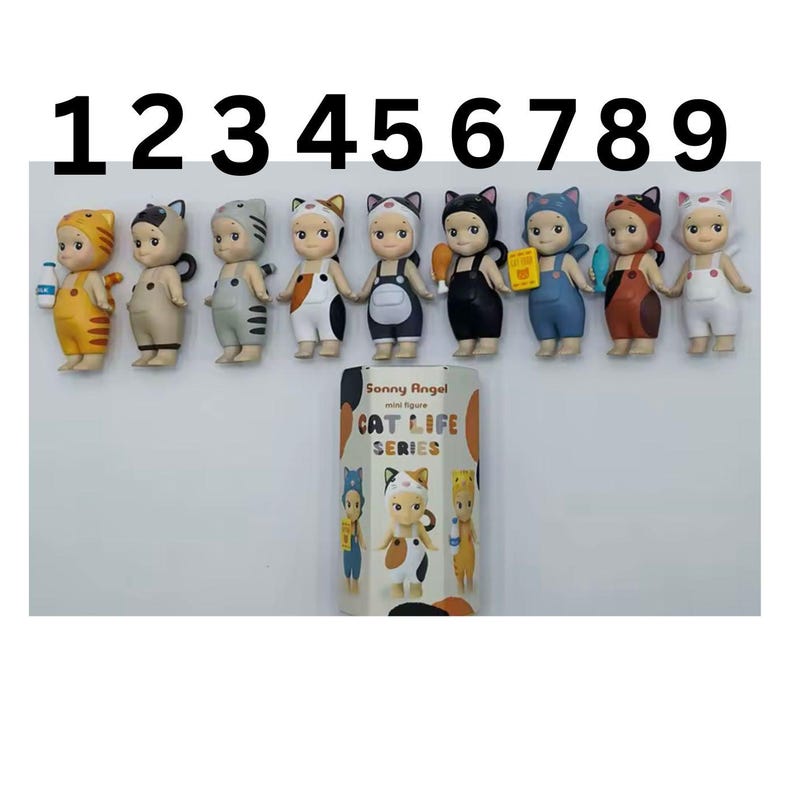 May include: A display of nine Sonny Angel mini figures from the Cat Life Series. Each figure is a small, stylised doll with cat-themed outfits and accessories. The figures are arranged in a row, with a box featuring the series' branding.