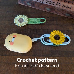 May include: Crochet sunflower cable organizers and a matching phone charger. The sunflower accents are yellow, brown, and green. The image also includes a yellow phone charger with a cartoon face and the text "Crochet pattern instant pdf download."