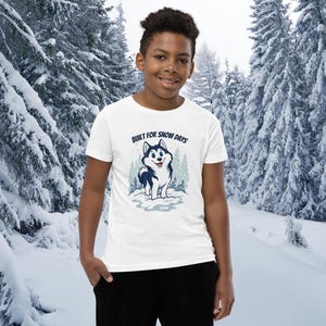 雪の日にぴったりのユースTシャツ（S～XL） – 雪景色に描かれたシベリアンハスキーの漫画が描かれた、柔らかい半袖コットンTシャツ