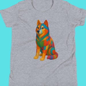 May include: A gray t-shirt featuring a colorful, stylized illustration of a dog. The dog is depicted in vibrant hues of orange, blue, green, and yellow, with a patchwork design. The shirt has a crew neck and short sleeves.