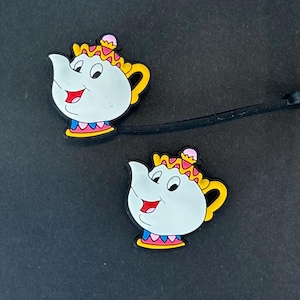 May include: A white ceramic mug with a black handle and the text "But First, Coffee" in a black, bold font. The mug is on a white surface. The mug is approximately 4 inches tall.