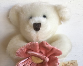 Peut inclure: Ours en peluche blanc tenant une fleur rose. L'ours a des yeux noirs et un nez brun. La fleur a un centre jaune. L'ours tient une étiquette qui dit "DanDee Collector's Choice".