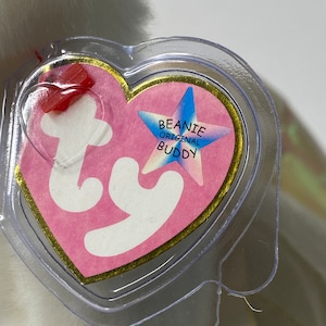 May include: White Beanie Baby with a pink heart-shaped tag that says "Beanie Original Buddy" with a blue star.