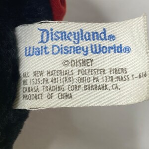 May include: White tag with blue text that reads "Disneyland Walt Disney World&reg; Disney" and "All new materials polyester fibers 1525:PA 4011(KR):Ohio PA 1378:MASS T-616 Canasa Trading Corp. Burbank, CA. Product of China."