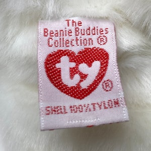 May include: White plush toy with a pink tag that reads "The Beanie Buddies Collection&reg;" and a red heart with the Ty logo. The tag also says "Shell 100% Tylok."