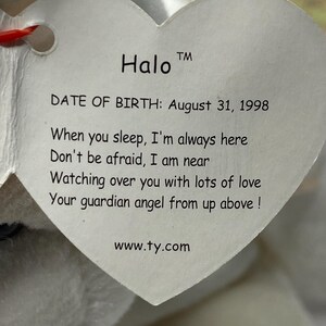 以下が含まれることがあります： 白いぬいぐるみで、ハート型のタグが付いています。タグには「Halo TM DATE OF BIRTH: August 31, 1998 When you sleep, I'm always here Don't be afraid, I am near Watching over you with lots of love Your guardian angel from up above! www.ty.com」と書いてあります。