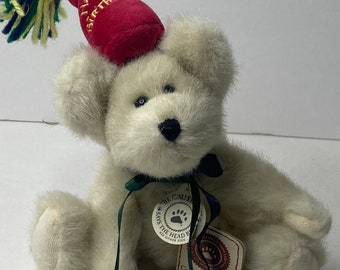 Peut inclure: Ours en peluche blanc portant un chapeau de fête rouge avec les mots "Joyeux anniversaire" dessus. L'ours est assis avec un ruban vert autour du cou et une étiquette qui dit "Soyez prudent" et "Dit l'ours en chef de l'autre côté".