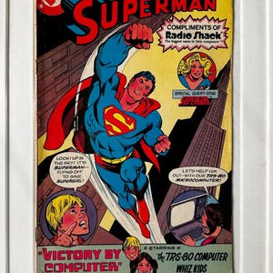 Puede incluir: Portada enmarcada de cómic vintage de Superman. Superman en vuelo, con un traje azul con capa roja y el icónico logo "S". La portada presenta el texto "Victory by Computer" y "The TRS-80 Computer Whiz Kids."
