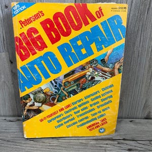 Puede incluir: Un libro de reparación de automóviles vintage de 1978, el « Big Book of Auto Repair » de Petersen. La cubierta amarilla presenta texto rojo y azul, con ilustraciones de piezas de automóviles. Cubre los coches americanos de 1970 y posteriores.