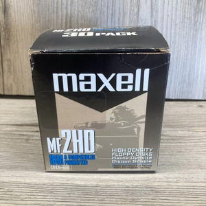 May include: A black box of Maxell MF2HD high-density floppy disks. The box features white text and graphics, including the Maxell logo and the text "30 PACK". The box also includes the text "IBM & COMPATIBLES FORMATTED".