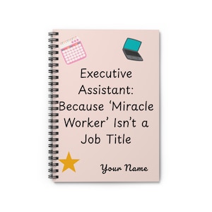 Puede incluir: Un cuaderno de espiral con una cubierta rosa claro. La cubierta presenta un calendario, un ordenador portátil y una estrella dorada. El texto dice "Executive Assistant: Because 'Miracle Worker' Isn't a Job Title" y "Your Name".