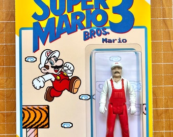May include: A retro-style action figure of Mario from Super Mario Bros. 3. The figure is packaged in a clear plastic blister pack with a yellow and blue cardboard backing. The backing features the Super Mario Bros. 3 logo and a pixelated image of Mario running on a platform.