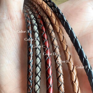 May include: Close-up of six braided leather cords in various colors: dark brown, brown with white, red, light brown, tan, and black. Each cord is labeled with a color name.