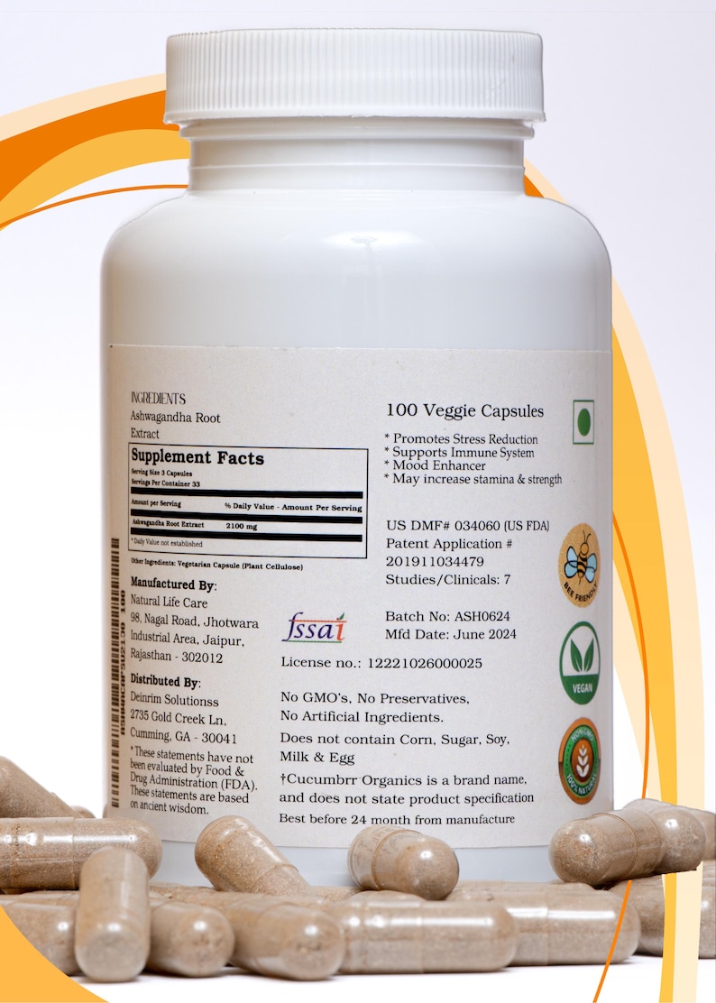 May include: A white bottle of 100 veggie capsules, containing Ashwagandha Root Extract. The label includes supplement facts, manufacturing details, and a vegan certification. Capsules are visible in the foreground.