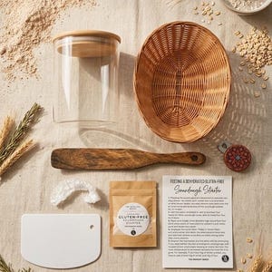 May include: A sourdough starter kit including a clear glass jar with a bamboo lid, a round woven wicker basket, a wooden spatula, a white plastic dough scraper, a small packet labelled Gluten-Free Sourdough Starter, and an instruction card.