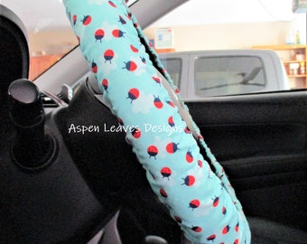 Ladybugs on blue steering wheel cover  Tiny red ladybugs flying in the clouds