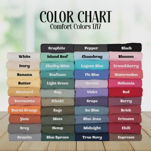 Pode incluir: Tabela de cores exibindo amostras de tecido Comfort Colors 1717. A tabela apresenta uma variedade de cores, incluindo branco, preto e v&aacute;rios tons de azul, verde e vermelho. O texto "COLOR CHART" est&aacute; no topo.