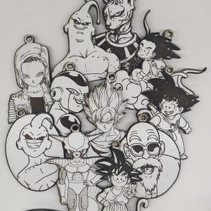 May include: A selection of laser-cut wooden Dragon Ball Z character ornaments. The black and white illustrations feature Goku, Vegeta, Frieza, and other popular characters. Each ornament has a small hole for hanging, ideal for fans of the anime series.
