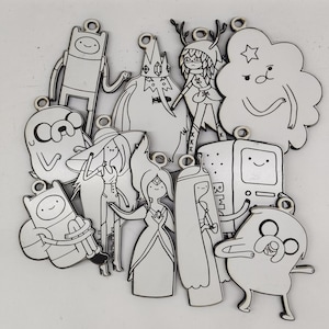 May include: A collection of Adventure Time character charms in a variety of poses. Each charm is outlined in black and has a small hole at the top for hanging. The charms include Finn, Jake, Princess Bubblegum, and other characters.