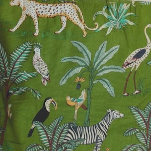 May include: A green fabric featuring a repeating pattern of wildlife and tropical plants. The design includes a cheetah, a zebra, a toucan, a cockatoo, and a long-legged bird, interspersed with palm trees and various leafy green foliage.