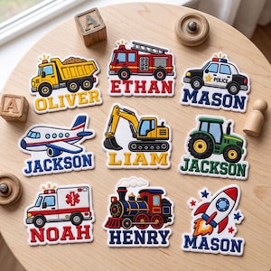 May include: A collection of nine colorful embroidered patches featuring various vehicles including a dump truck, fire engine, police car, airplane, excavator, tractor, ambulance, train, and rocket, each personalized with names like Oliver, Ethan, Mason, Jackson, Liam, Noah, and Henry.