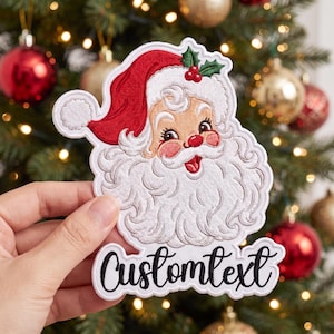 May include: An embroidered patch featuring a smiling Santa Claus with a white beard, red hat, and green holly leaves with red berries. The patch has a white border and the black text Customtext written in a cursive script at the bottom.