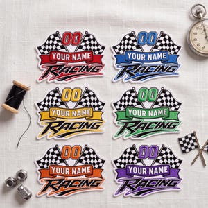 May include: Six embroidered racing patches featuring checkered flags, the number 00, and the text YOUR NAME RACING in red, blue, yellow, green, orange, and purple. Each patch includes a banner for personalization alongside a spool of thread and a stopwatch.