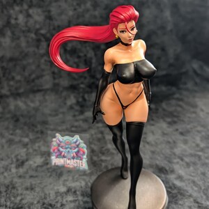 May include: A detailed figurine of a woman with bright red hair, wearing a black tube top, gloves, and thigh-high stockings. The figure is posed on a circular base with a logo, showcasing intricate details and vibrant colors.