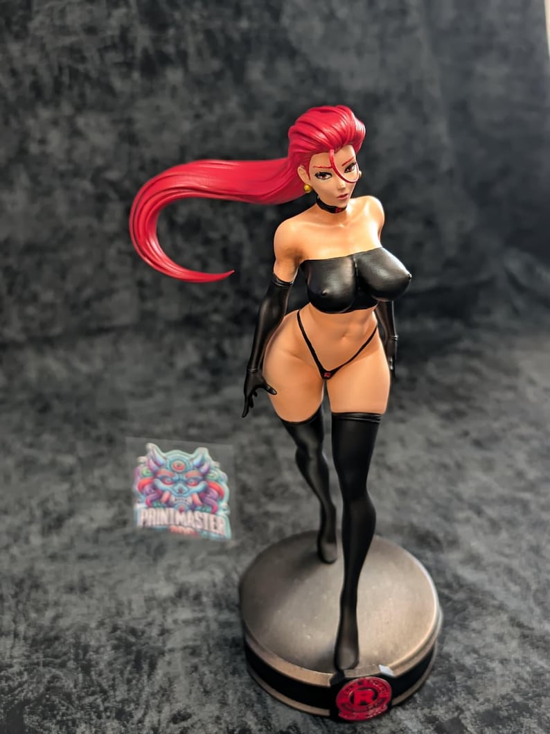 May include: A detailed figurine of a woman with bright red hair, wearing a black tube top, gloves, and thigh-high stockings. The figure is posed on a circular base with a logo, showcasing intricate details and vibrant colors.
