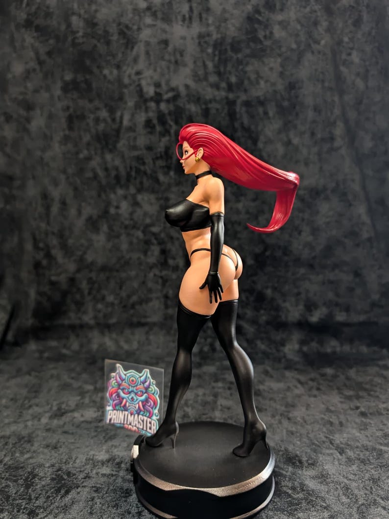May include: A figurine of a woman with long red hair, wearing a black outfit, including a top, gloves, and thigh-high stockings. The figure is posed on a black circular base. The figurine has a detailed design and is a collectible item.