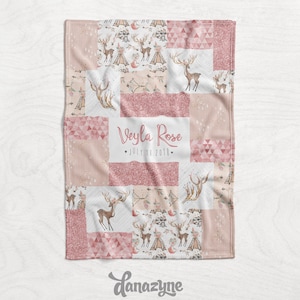 May include: A pink and white patchwork baby blanket with a deer and teepee pattern. The blanket features the name "Veyla Rose" and the date "July 13, 2018". The blanket is made of soft material.