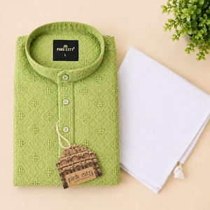 K&ouml;nnte beinhalten: Ein lindgr&uuml;ner, lang&auml;rmeliger Kurta mit einem komplizierten, tonalen Stickmuster, Stehkragen und Knopfleiste. Ein schwarzes Etikett im Inneren zeigt PINK CITY L. Ein wei&szlig;es, gefaltetes Stoffst&uuml;ck und ein Markenanh&auml;nger liegen bei.