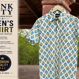 May include: White short-sleeved shirt with a blue and olive green floral pattern. The shirt is hand block printed and made of 100% cotton. The text on the left side of the image reads "PINK CITY JAIPUR HAND BLOCK MEN'S SHIRT".