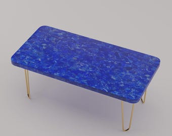 May include: A rectangular coffee table with a vibrant blue mosaic top and gold hairpin legs. The table's surface has a textured appearance, with a length of approximately 48 inches and a width of 24 inches.