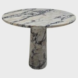 Op de afbeelding: Een ronde marmeren tafel met een wit en grijs patroon op het blad en een enkele, cilindrische voet. De tafel heeft een diameter van ongeveer 76 cm en is ongeveer 71 cm hoog. Het marmer heeft een natuurlijk aderingpatroon.